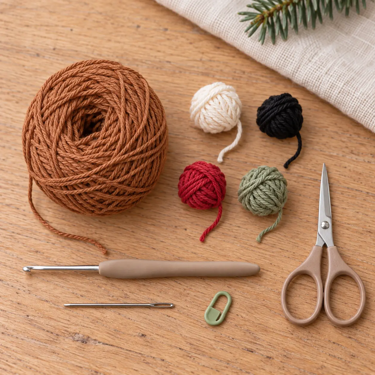 Material zum Lebkuchenmann häkeln mit braunem Baumwollgarn, cremefarbenen Garnresten und Häkelnadel