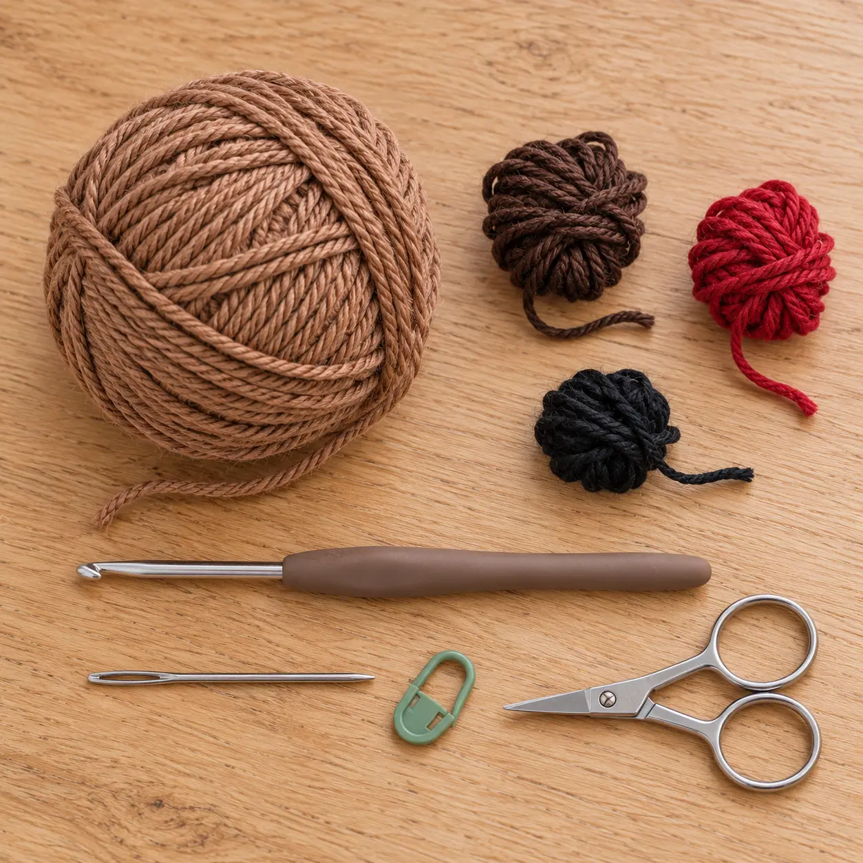Material zum Rentier häkeln mit braunem Baumwollgarn, roten Garnresten und Häkelnadel